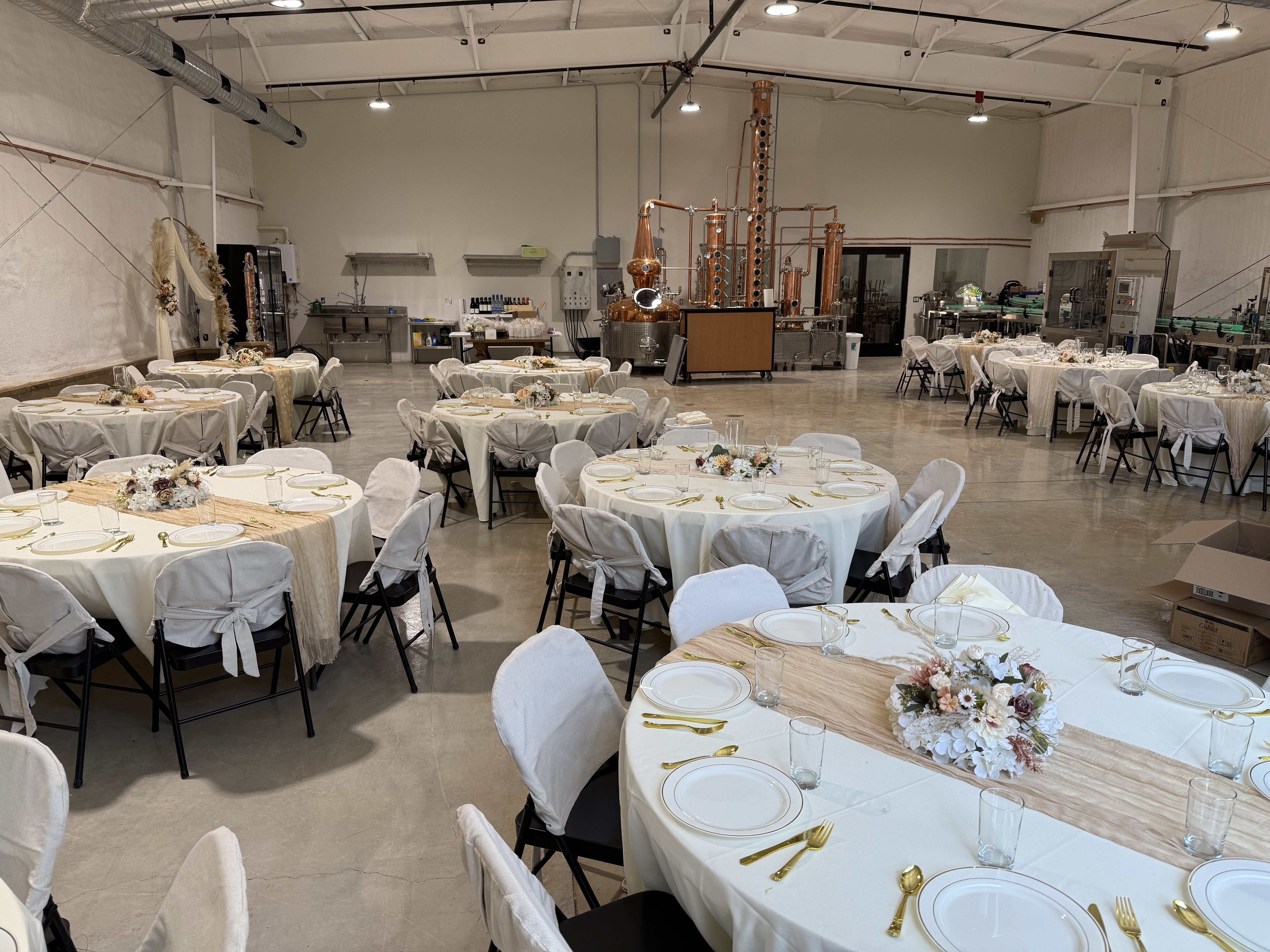 The distillery floor set with round tables for a past reception